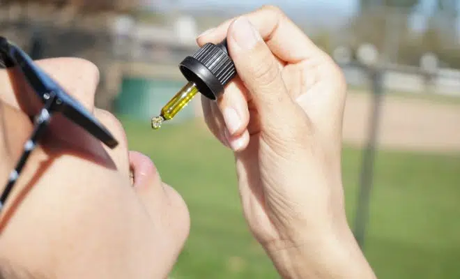 person holding black and yellow bottle