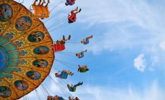 people riding carnival ride under blue skies