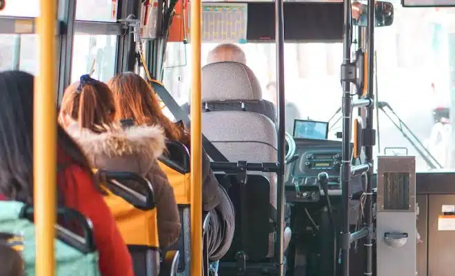 woman in orange jacket sitting on bus seat