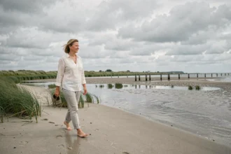 Femme se promenant pieds nus sur la plage des marais de Pennedepie en Normandie lors d'une marée basse